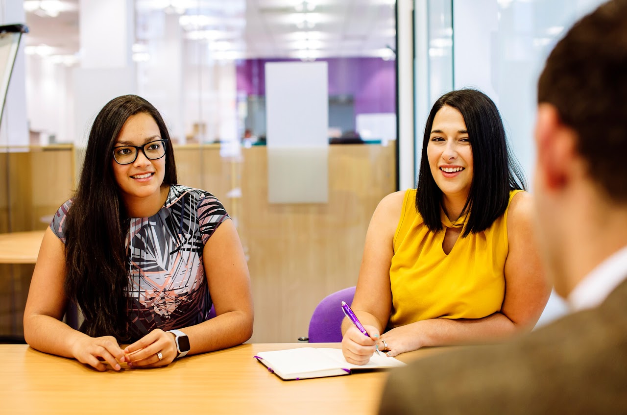 Two members of staff sitting in a meeting
