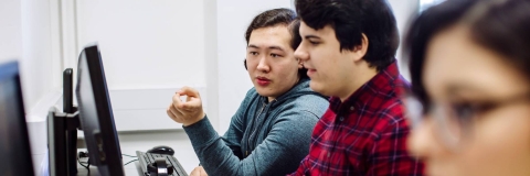 Students discussing work in an IT suite